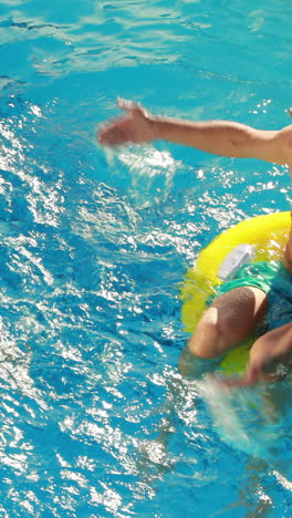 Couple-sitting-on-inflatable-rings-in-the-swimming-pool