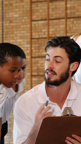 Sports-teacher-having-discussion-with-his-students