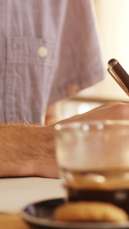 Two-men-writing-on-a-notepad-in-cafe