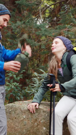 Hiker-couple-interacting-with-each-other-in-forest