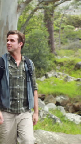 Smiling-man-hiking-through-a-forest