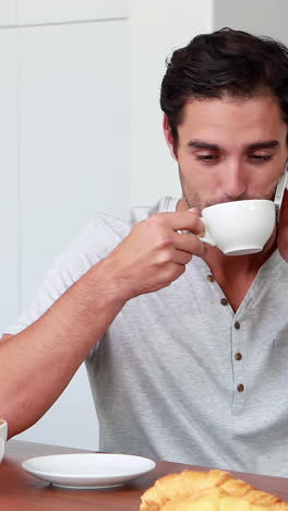 Handsome-man-on-phone-call-during-breakfast