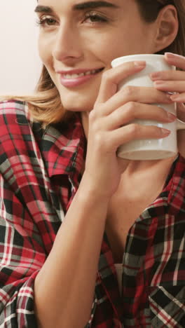 Smiling-woman-using-laptop-while-drinking-coffee