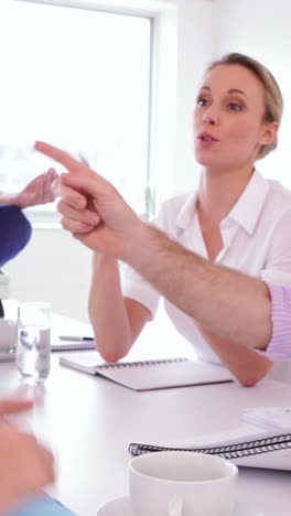 Handsome-businessman-meditating-while-his-colleagues-are-arguing