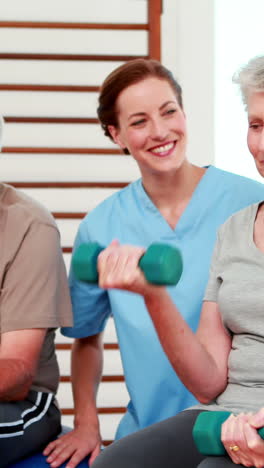 Happy-senior-citizens-exercising-with-physiotherapist