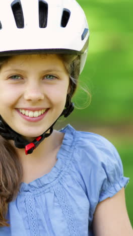 Little-girl-smiling-at-camera-on-a-pink-bike