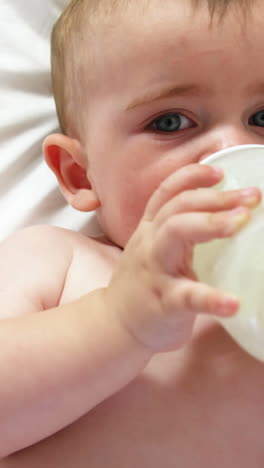 Süßes-Baby-Liegt-Und-Trinkt-Aus-Seiner-Babyflasche