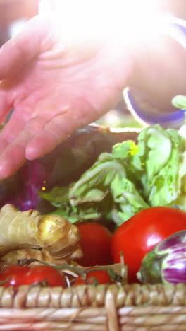 Male-staff-assisting-woman-in-selecting-fresh-vegetables