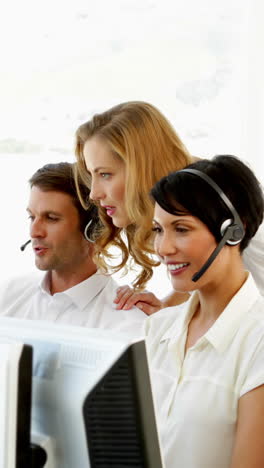 Supervisor-checking-on-call-centre-workers