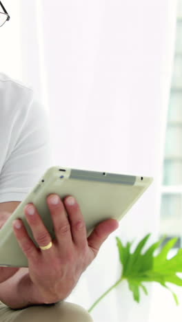 Smiling-man-using-his-tablet