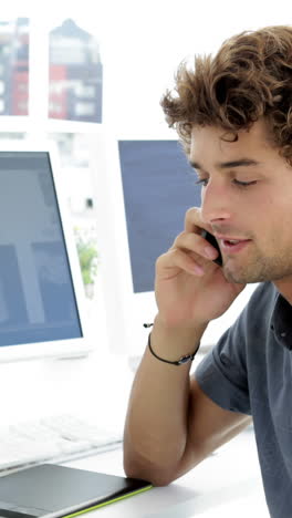 Handsome-young-creative-designer-phoning-with-his-phone-