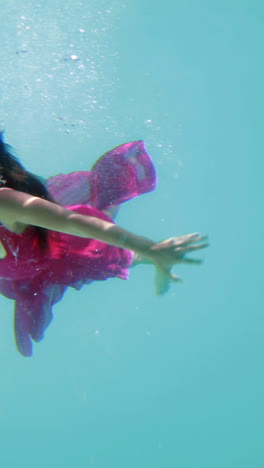 Brunette-in-evening-gown-diving-into-swimming-pool