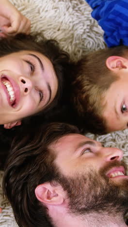 Happy-family-smiling-and-lying-on-a-carpet