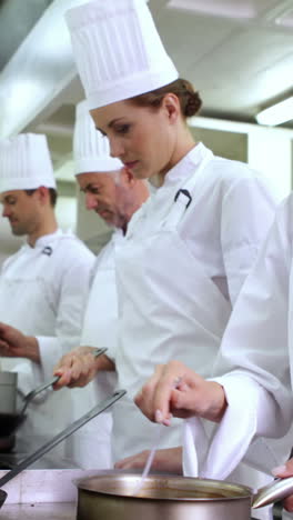 Chef-stirring-sauce-smiling-at-camera