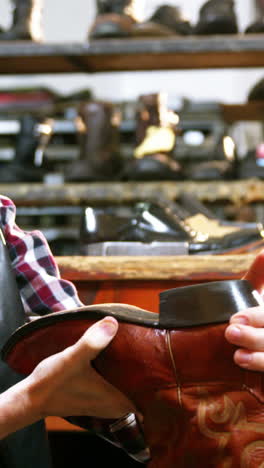 Shoemaker-examining-a-shoe