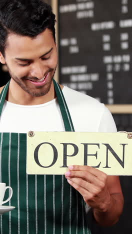 Smiling-waiter-holding-sign-and-coffees-cup