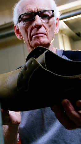 Shoemaker-examining-a-shoe