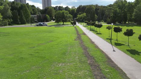 Parkside-during-a-beautiful-summer-day-surrounded-by-lush-greenery,-grass,-and-trees-under-a-clear-blue-sky