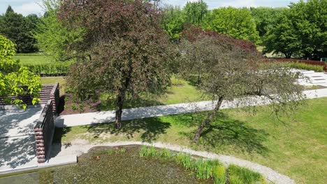 Parque-Durante-Un-Hermoso-Día-De-Verano-Rodeado-De-Exuberante-Vegetación,-Césped-Y-árboles-Bajo-Un-Cielo-Azul