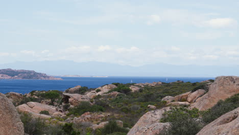 Ruhige-Küste-Sardiniens-Mit-Schroffen-Felsen-Und-Yachten-Auf-Dem-Meer