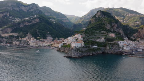 Aerial:-Panoramic-drone-shot-of-Amalfi-village-on-Amalfi-coast,-Italy-during-sunset