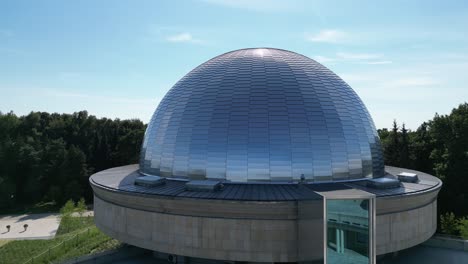 Great-stars-observatory-during-a-beautiful-summer-day,-surrounded-by-lush-greenery,-grass,-and-trees-under-a-clear-blue-sky