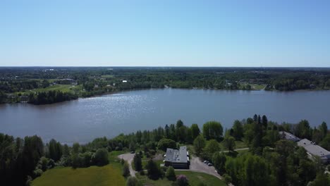 Aerial-dolly-over-vibrant-northern-boreal-forest-lake-community-homes