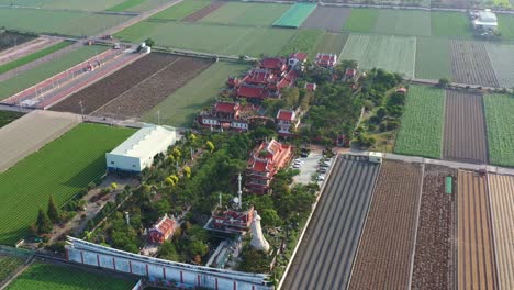 Aerial-view-of-a-traditional-Chifa-Matsu-Temple-amidst-agricultural-fields,-a-sacred-site-dedicated-to-the-goddess-of-sea,-showcasing-a-blend-of-cultural-heritage-and-rural-landscape,-Yunlin,-Taiwan