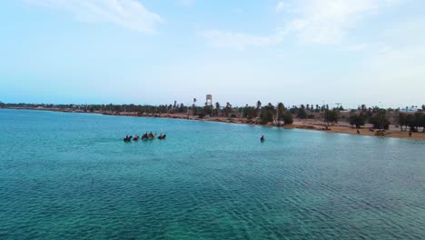 Una-Vista-Aérea-De-Varias-Personas-Montando-Caballos-Y-Camellos-En-La-Superficie-De-La-Laguna-De-Djerba-En-Túnez.