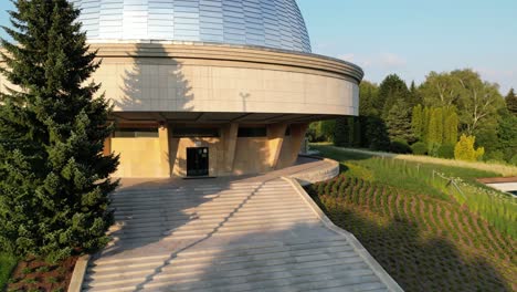 Great-stars-observatory-during-a-beautiful-summer-day,-surrounded-by-lush-greenery,-grass,-and-trees-under-a-clear-blue-sky