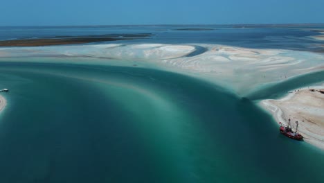 Una-Vista-Aérea-De-La-Escena-De-La-Playa-Acuática-De-Hassi-El-Jerbi-Con-Personas-Y-Barcos-En-El-Agua-En-Zarzis-Túnez