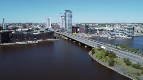 Vehicle-traffic-on-sunny-Kulosaari-Bridge,-aerial-over-Helsinki-FIN