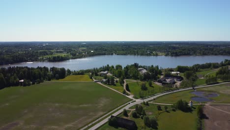 Flyover-lakeside-country-homes-on-peaceful-blue-northern-lake,-Finland