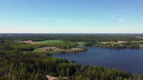 Lebendige-Landschaft-Im-Norden:-Grüner-Wald,-Blauer-See,-Blauer-Himmel-Am-Horizont