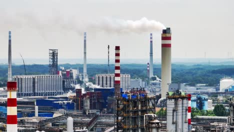 Vista-Aérea-De-Drones-En-Terminal-Petrolera-Con-Humo-De-Chimeneas-En-Instalaciones-Industriales-Para-Almacenamiento-De-Petróleo-Y-Petroquímicos