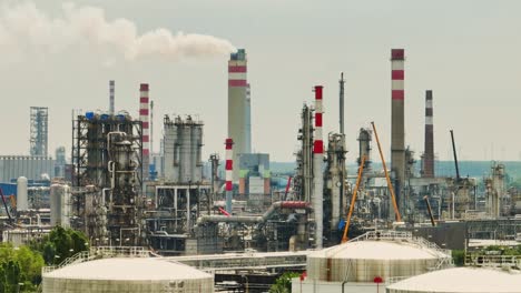 Aerial-drone-view-on-oil-terminal-with-smoke-from-chimneys-in-industrial-facility-for-storage-of-oil-and-petrochemical