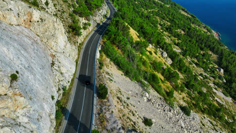 Aerial:-EV-car-driving-on-a-mountain-road-in-the-Makarska-riviera,-Croatia