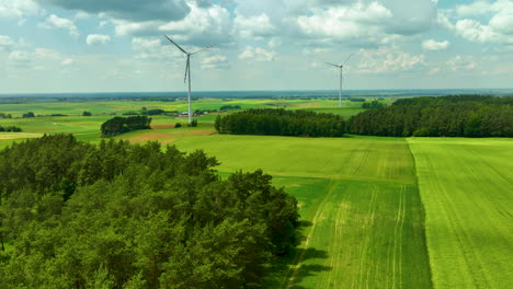 Aerial-footage-featuring-two-wind-turbines-set-in-a-vast,-green-rural-landscape-under-a-partly-cloudy-sky