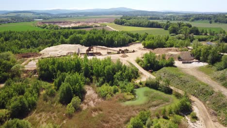 An-Old-Sand-Mine-Located-in-the-Midst-of-a-Lush-Green-Landscape-Near-the-town-of-Prudnik,-Poland---Drone-Flying-Forward