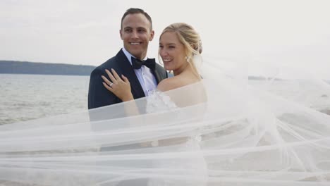 La-Novia-Y-El-Novio-Sonríen-Mientras-Lil-Sopla-En-El-Viento.