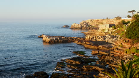 Picturesque-Hermanus-rocky-coastline-and-sea-cliffs,-view-toward-Old-Harbour