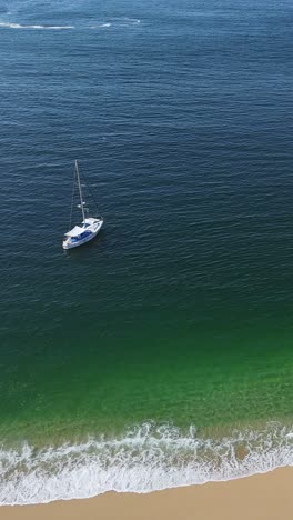 Barco-Navegando-En-Una-Playa-De-Huatulco,-Oaxaca,-Modo-Vertical