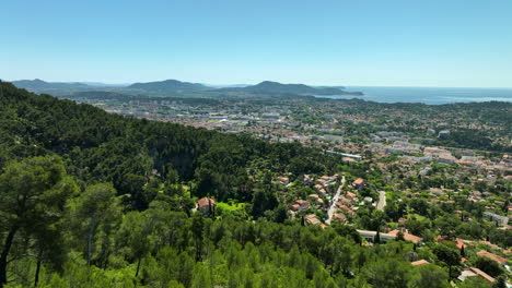 Aerial-flying-over-green-mountain-towards-Toulon-on-sunny-day,-France