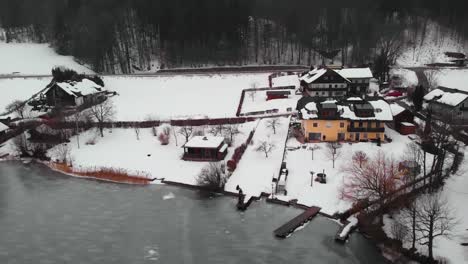 Frozen-Lake-Fuschl-in-Austria,-drone-shot-of-picturesque-houses-by-the-shore,-HD