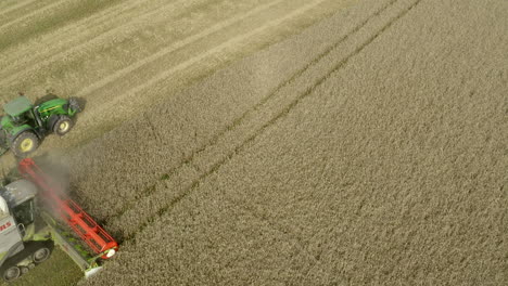 Static-drone-shoot-of-Harvester-Combine-working-and-offloading-collected-grain-in-parallel-trailer