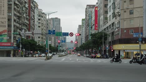 Calle-En-Taiwán-Durante-El-Tráfico-Matutino-Compuesto-Por-Ciclomotores-Y-Automóviles-Que-Van-De-Izquierda-A-Derecha