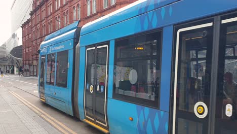 Close-up-West-Midlands-Metro-light-rail-tram-system-passing-by-in-the-city-centre-in-the-county-of-West-Midlands,-Birmingham,-England-UK