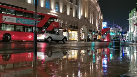 Double-decker-famous-red-city-bus-and-car-traffic-in-London-on-rainy-night