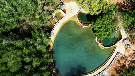 Mujer-En-Maquinit-Piscina-De-Aguas-Termales-Alejando-El-Zoom-Aéreo