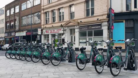 Rows-of-bikes-for-cycle-hire-parked-at-docking-station-outside-Grand-Central-train-station-in-city-centre-of-Birmingham,-the-Midlands-of-England-UK